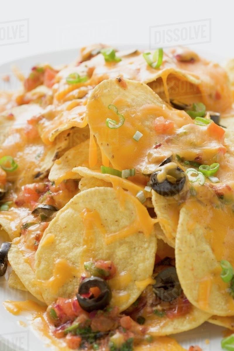 Tortilla chips with melted cheese and olives Stock Photo Dissolve