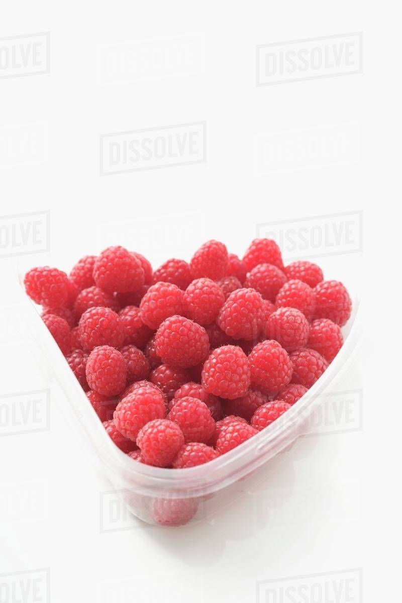 Raspberries in plastic container Stock Photo Dissolve