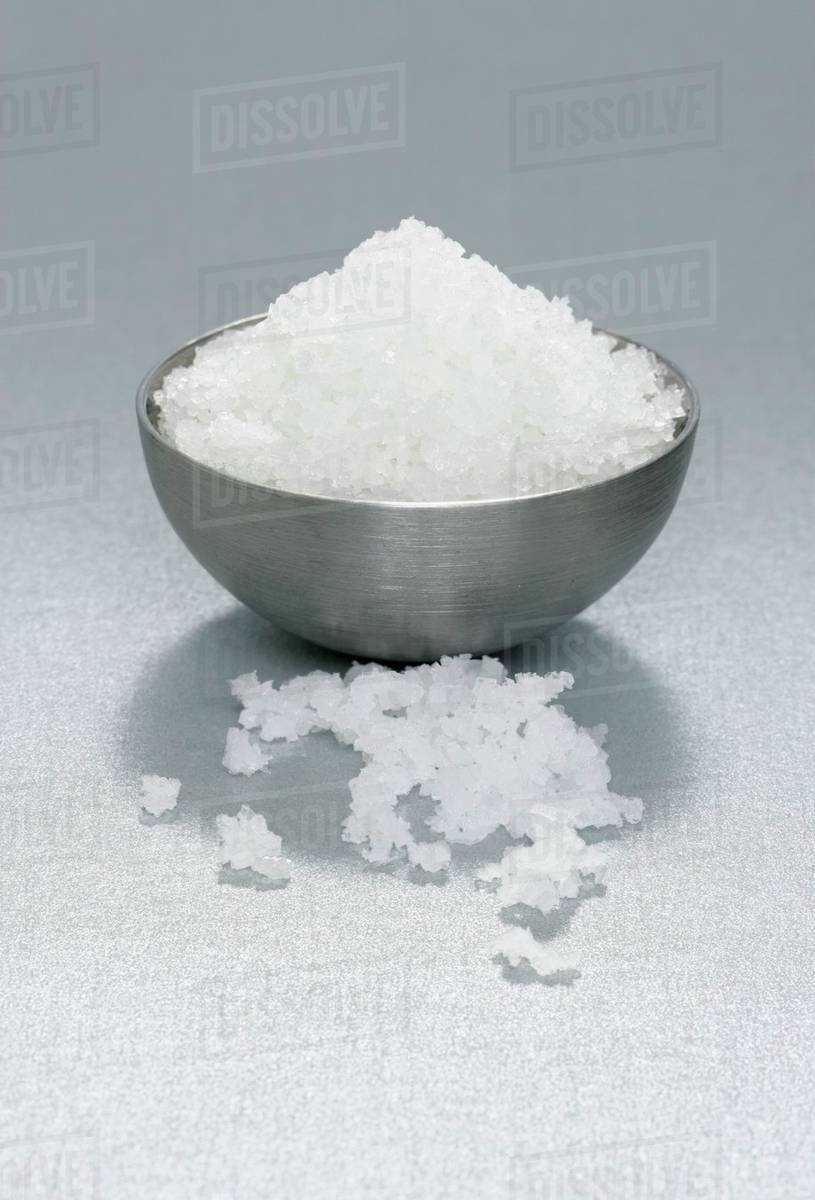 Fleur de sel in and beside metal dish Stock Photo Dissolve