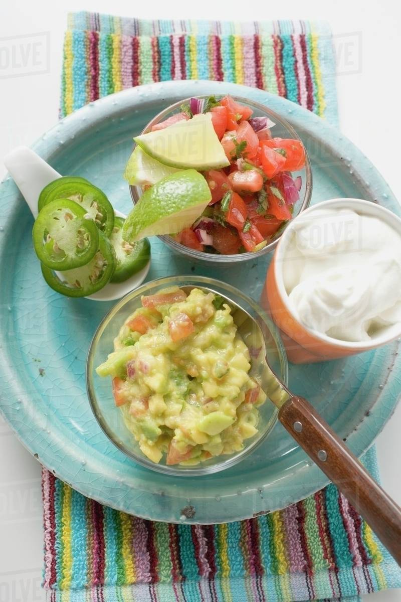 Guacamole, salsa and sour cream on plate (Mexico) Stock Photo Dissolve