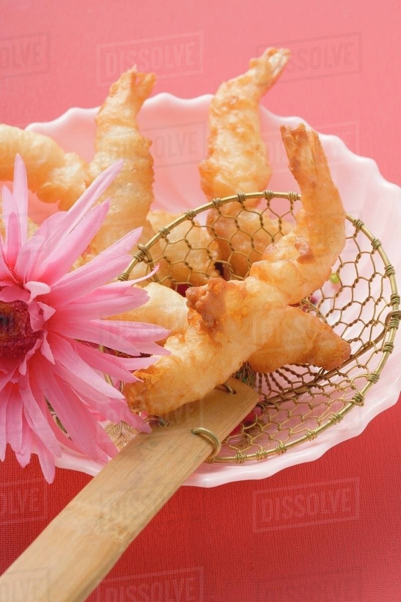 Deepfried prawns in batter in straining spoon (Asia) Stock Photo
