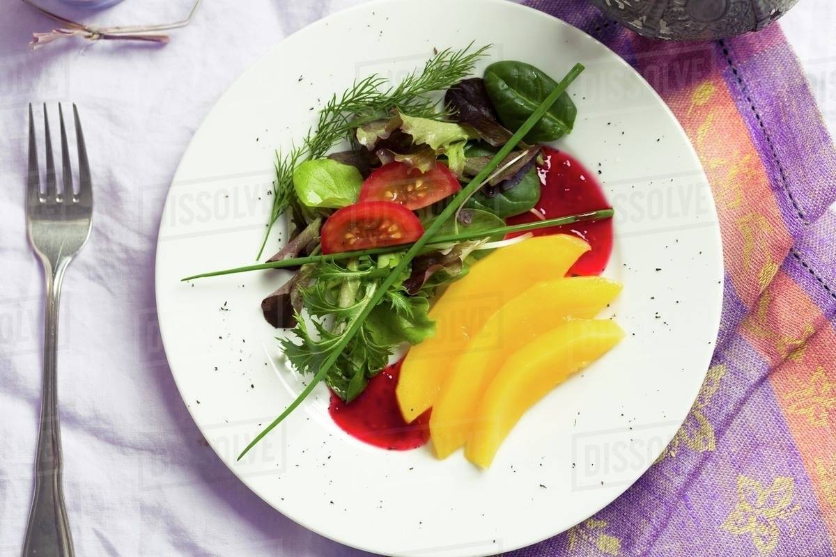 Mixed leaf salad with mango, tomatoes and a raspberry dressing Stock
