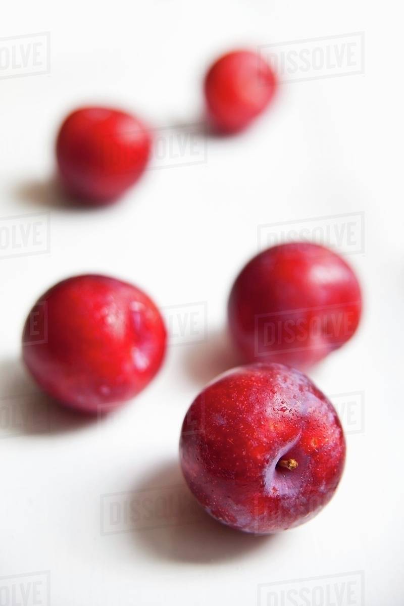 Five freshly washed organic plums Stock Photo Dissolve