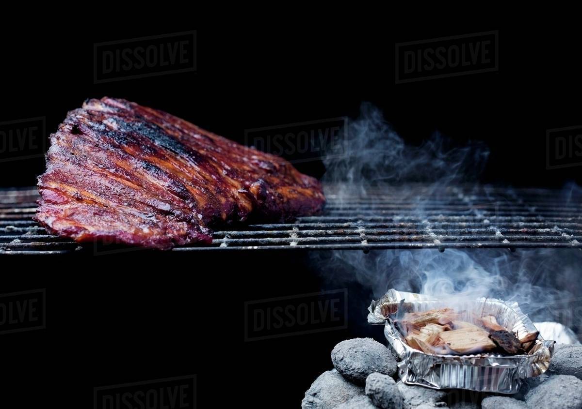 Whole Rack of Pork Ribs on Grill with Barbecue Sauce Stock Photo