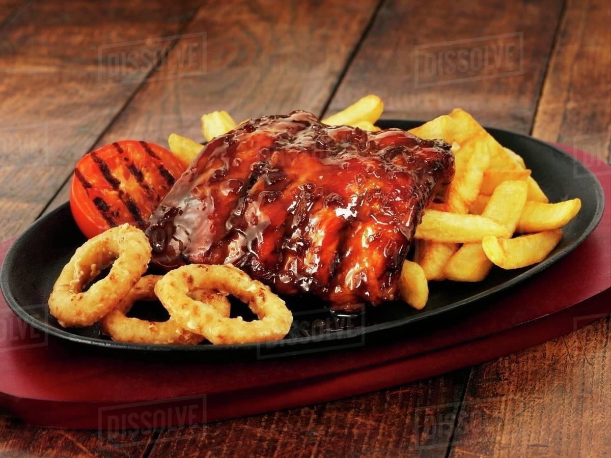 Glazed ribs with chips and onion rings Stock Photo Dissolve