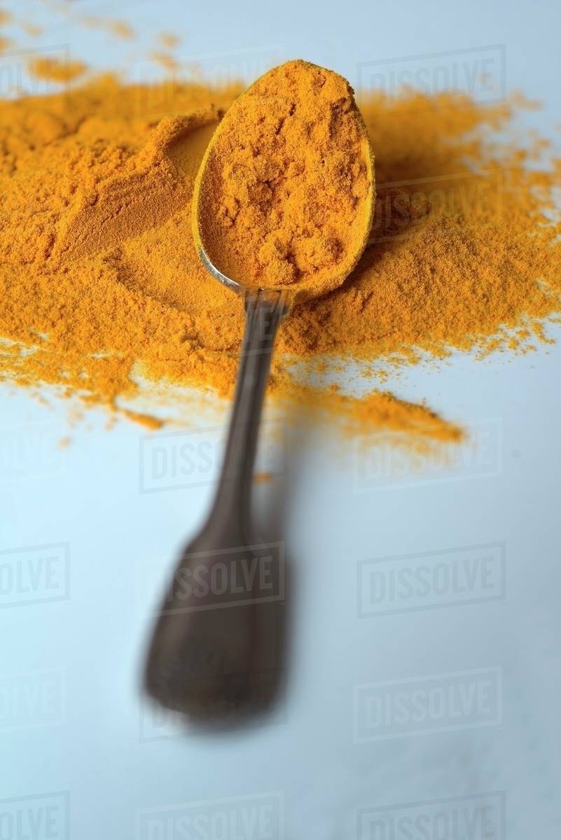 Turmeric powder on a spoon Stock Photo Dissolve