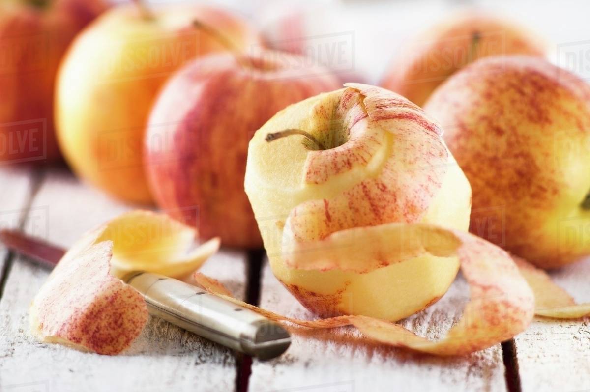 Royal Gala apples, one peeled Stock Photo Dissolve