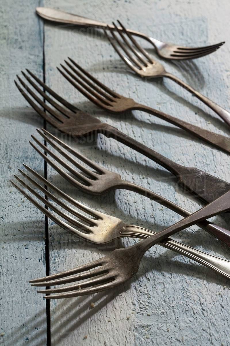 Old forks on a wooden surface Stock Photo Dissolve