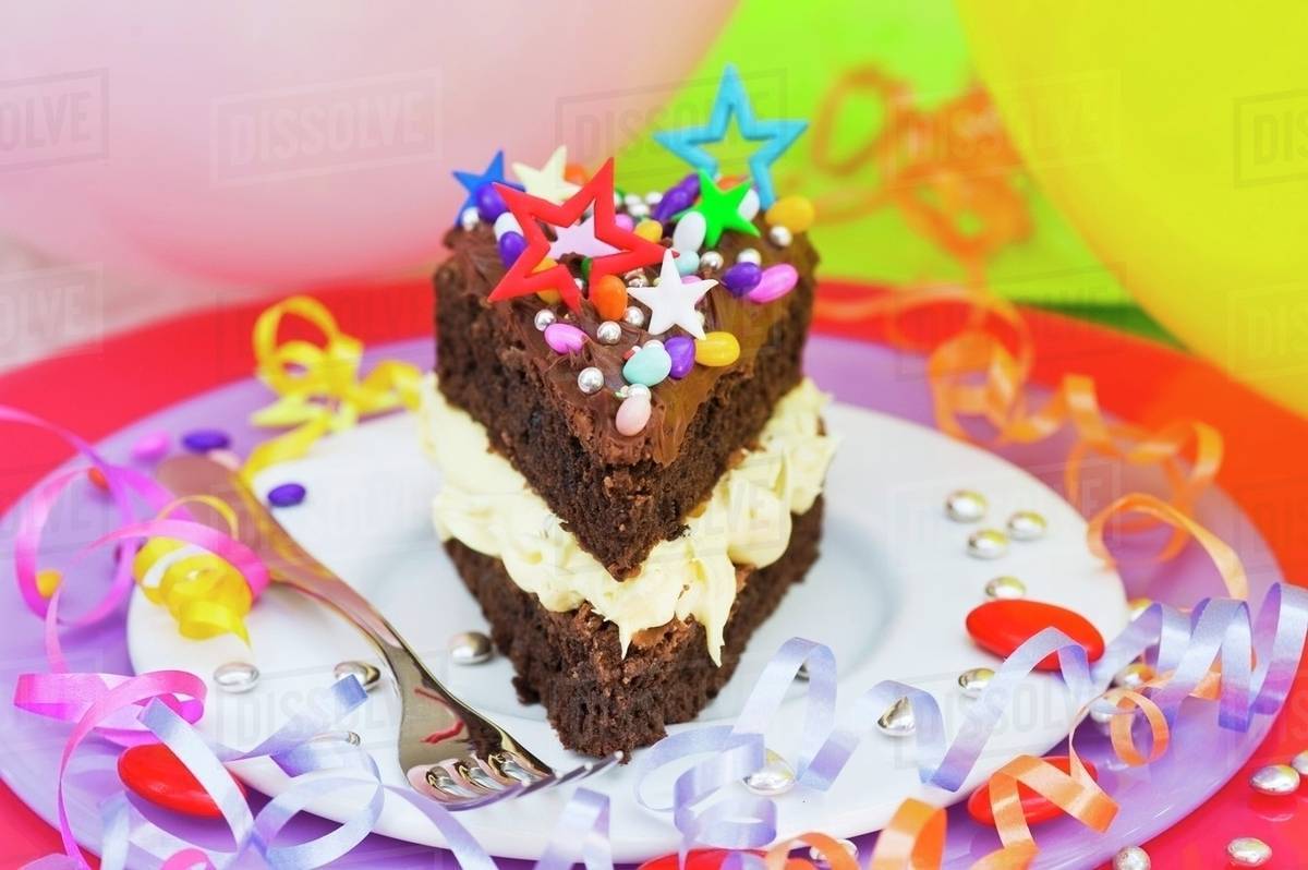 A Piece Of Chocolate Cake With Colorful Sprinkles And Candy
