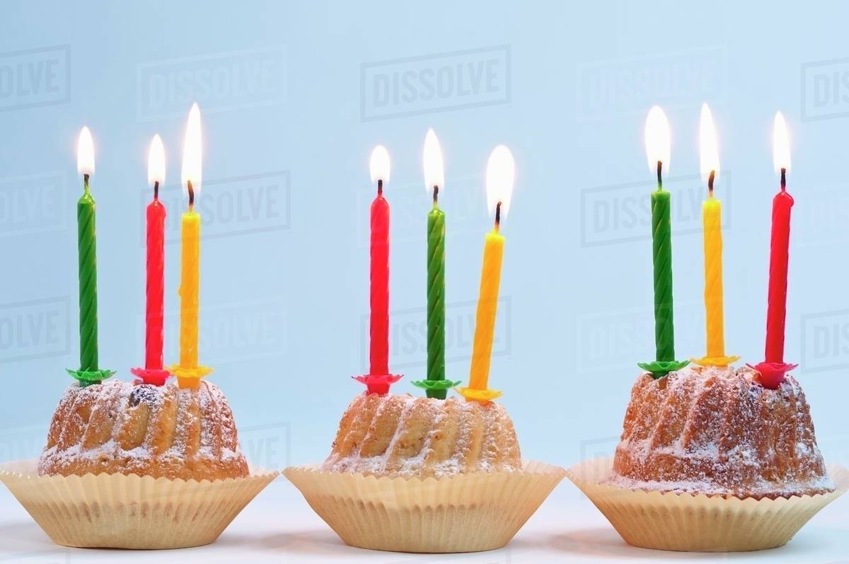three bundt cakes with lit candles for a birthday stock photo