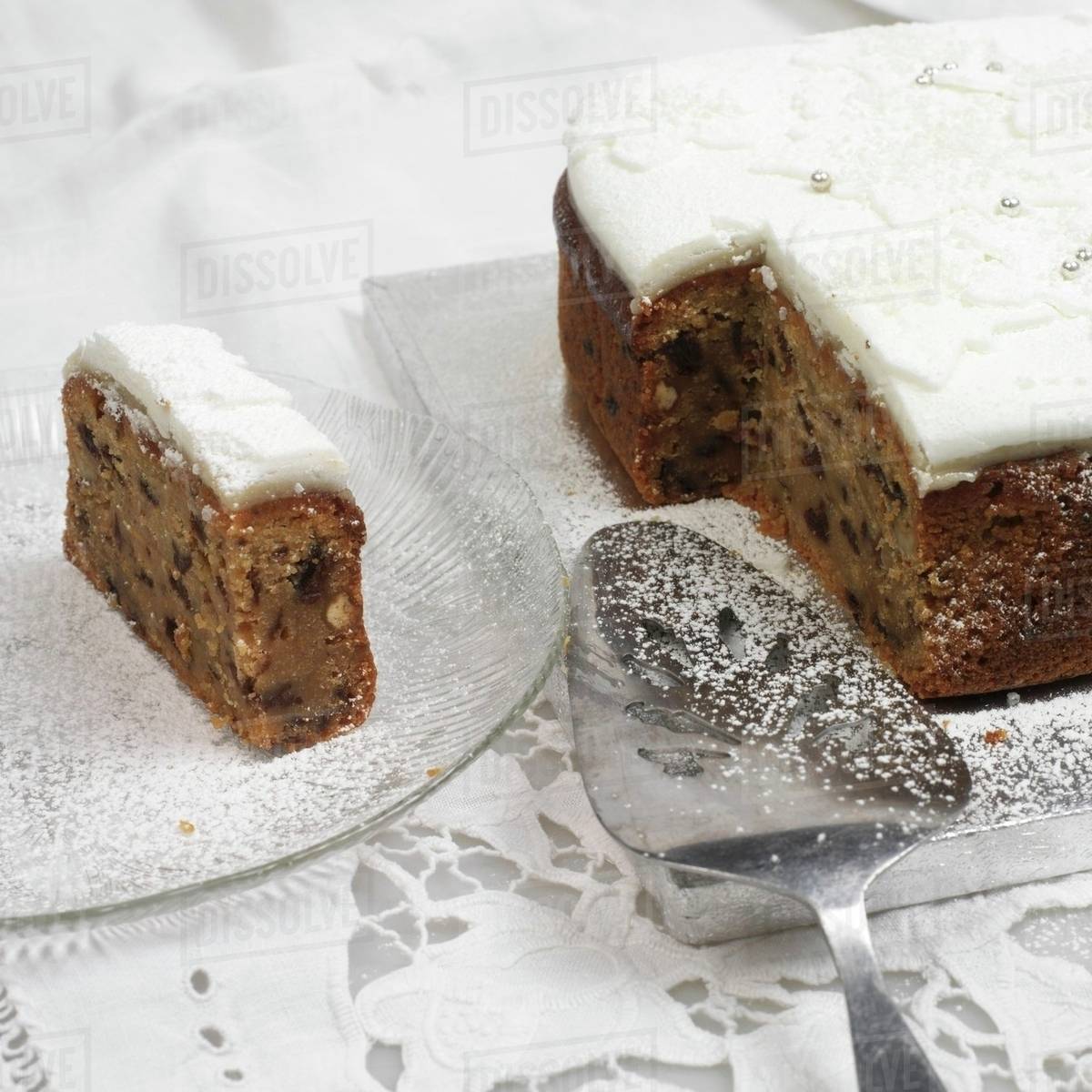 Partly sliced fruit cake with icing Stock Photo Dissolve