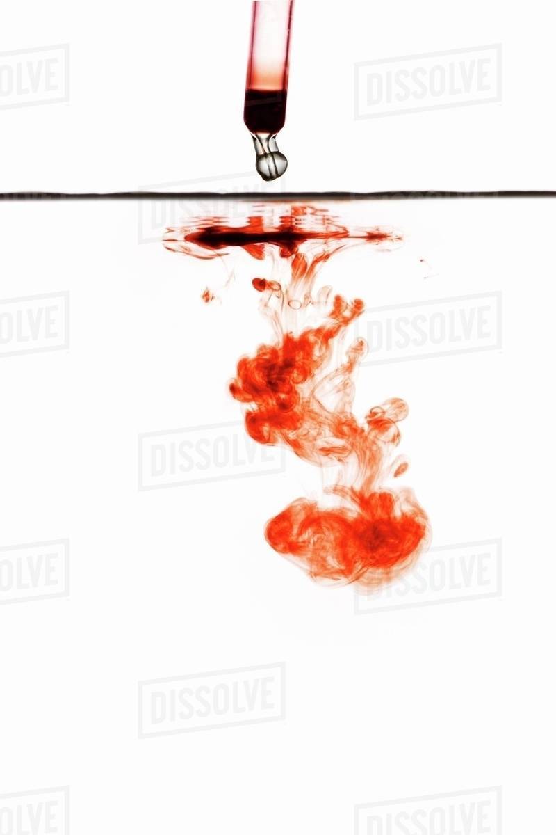 Red wine dripping from a pipette into water Stock Photo Dissolve