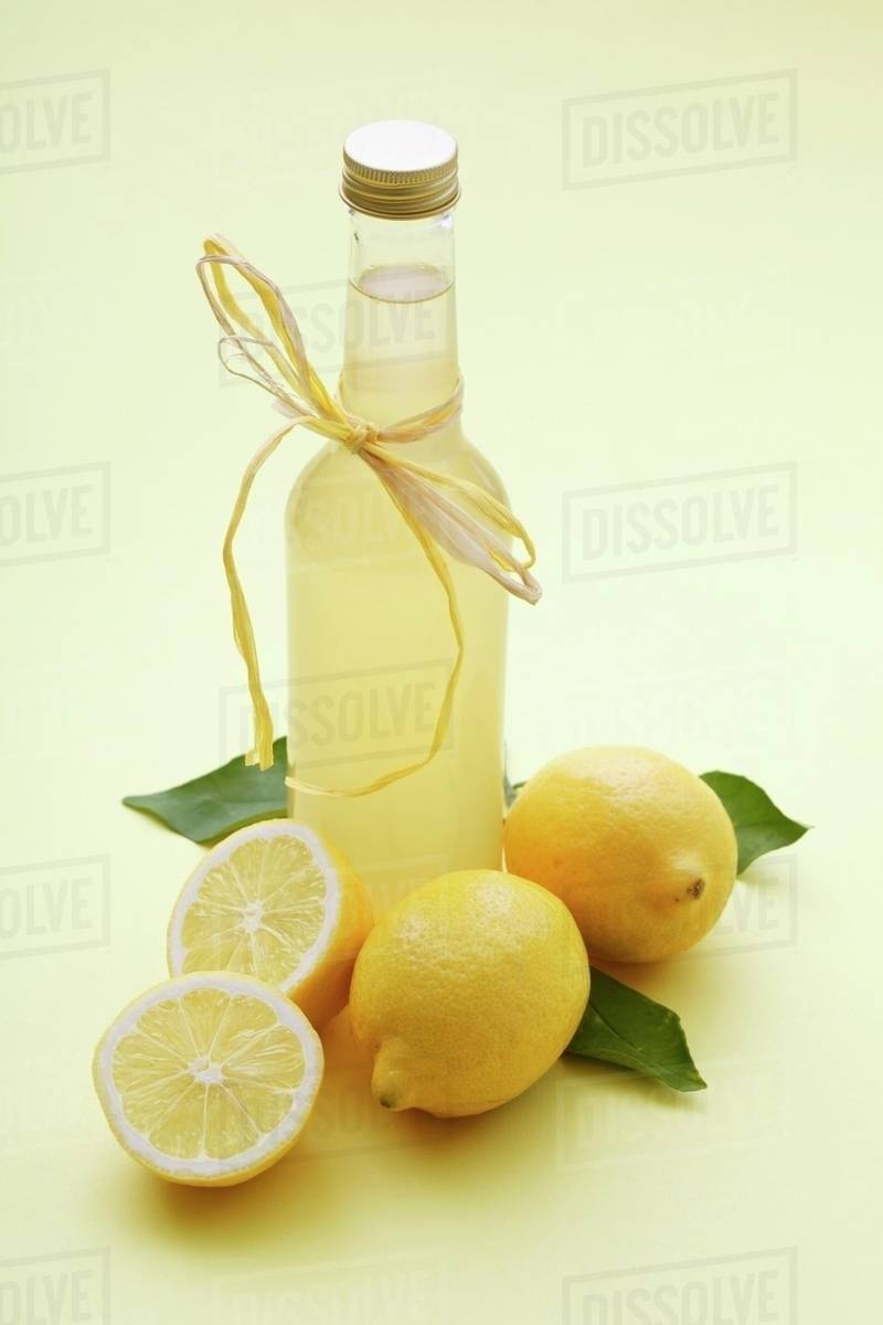 A bottle of lemonade and fresh lemons Stock Photo Dissolve