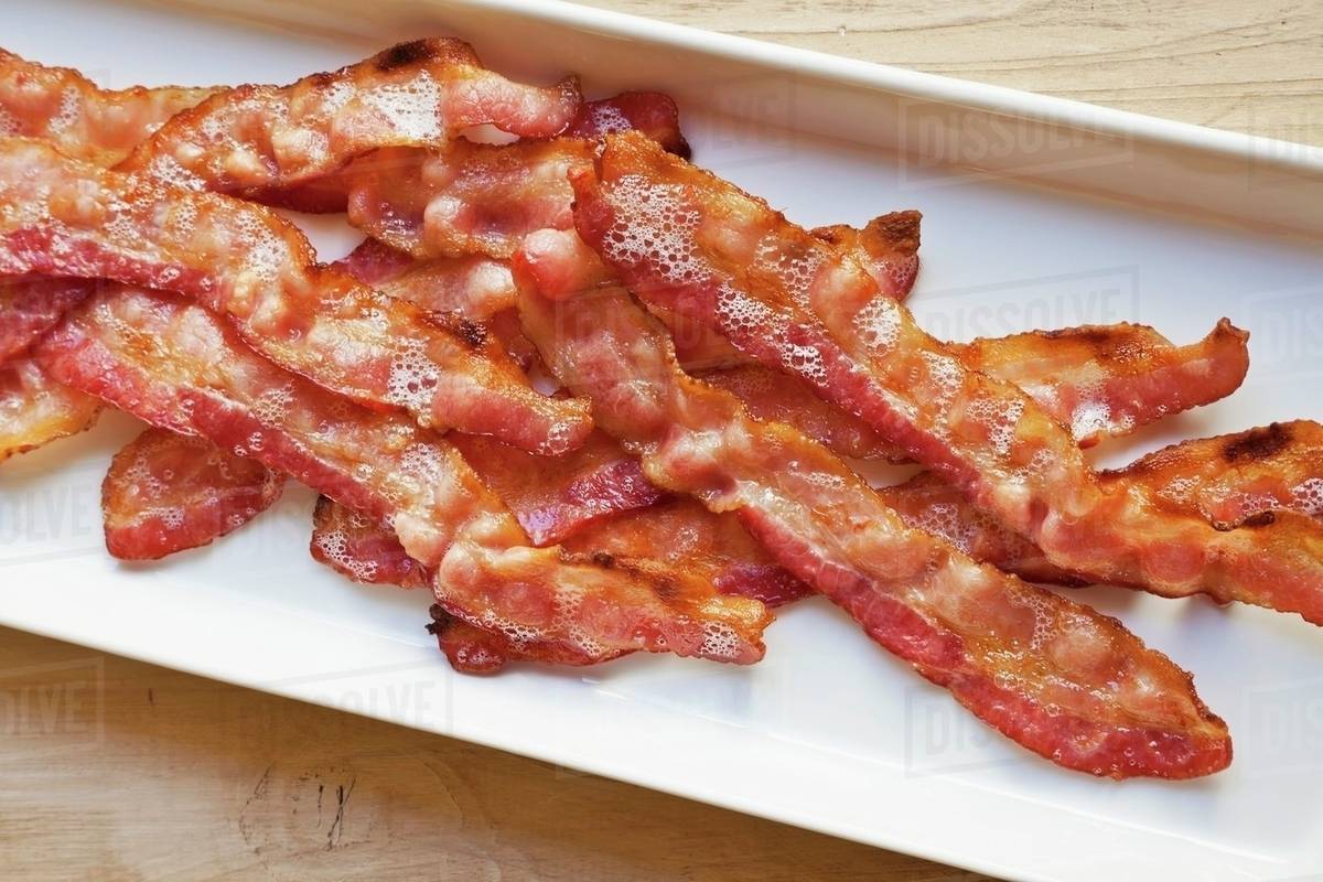 Oven Broiled Bacon in a White Serving Platter - Stock Photo - Dissolve