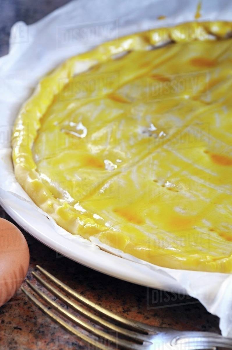 Spicy quiche being brushed with egg yolk Stock Photo Dissolve