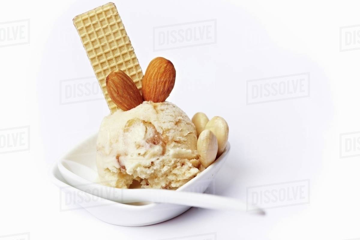 Almond ice cream with almond brittle and a wafer in an ice cream dish
