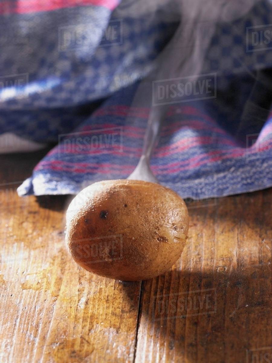 A whole steaming new potato Stock Photo Dissolve