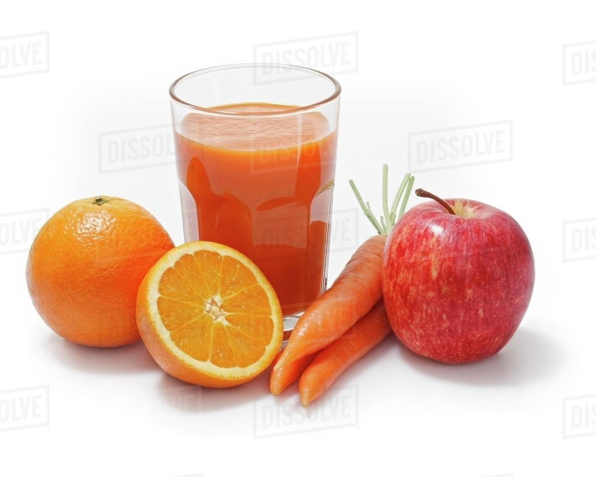 Multivitamin juice surrounded by oranges, apples and carrots Stock