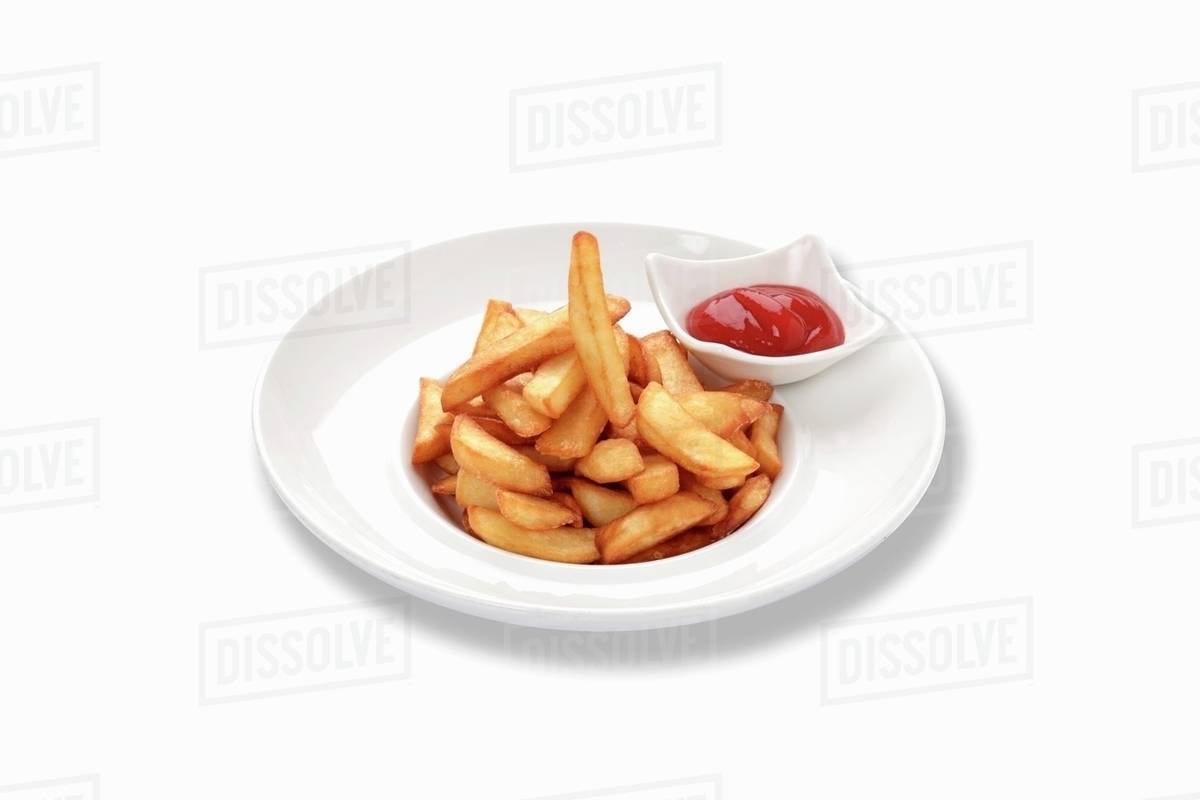 Ketchup on French fries, closeup, elevated view Stock Photo Dissolve