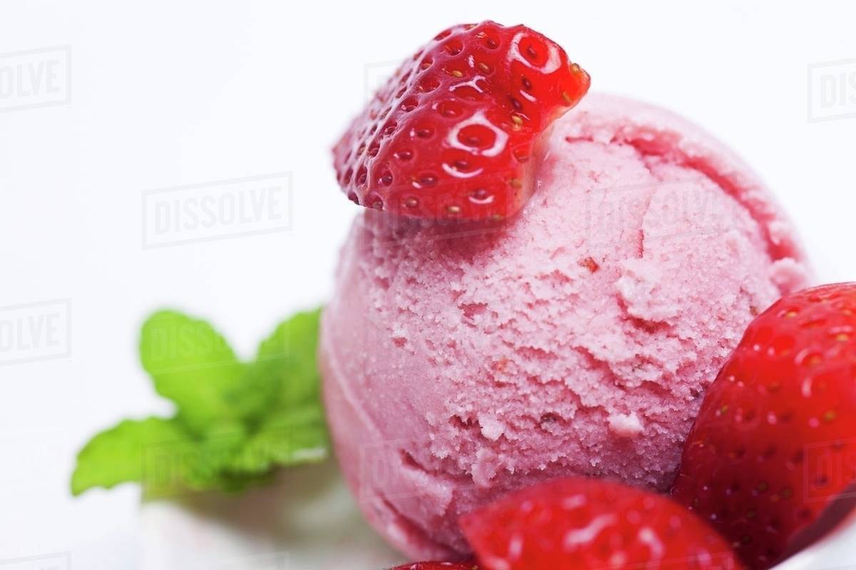a scoop of fresh strawberry ice cream with fresh strawberries