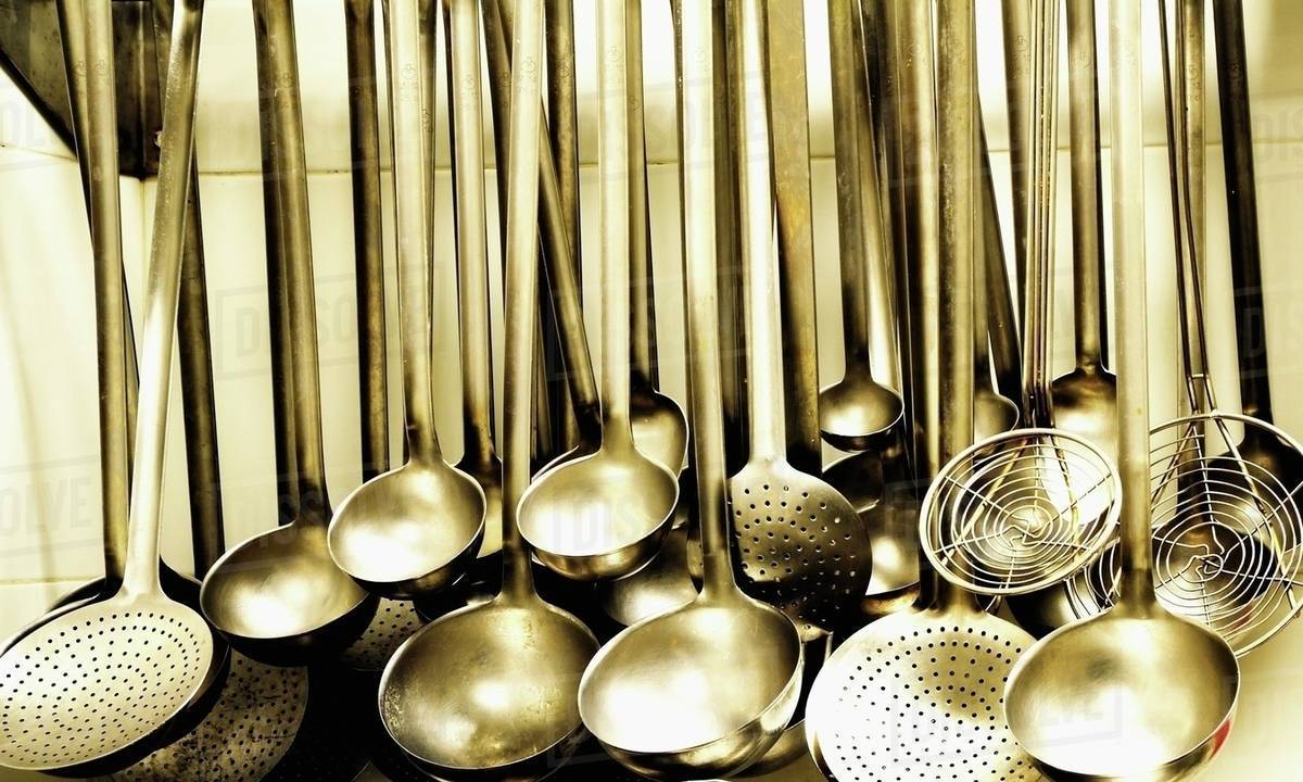 Ladles and strainer spoons in a large kitchen Stock Photo Dissolve
