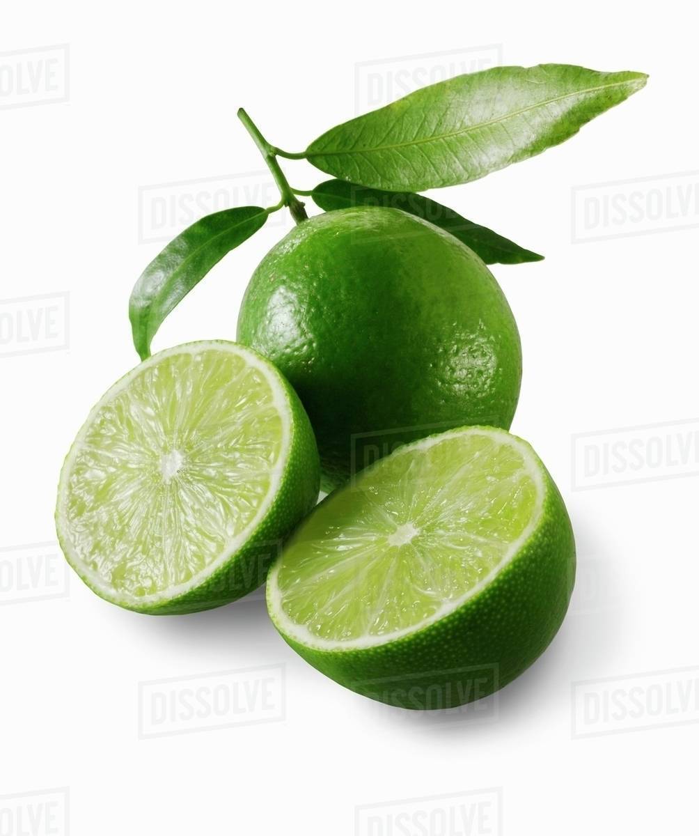Two lime halves in front of a whole lime Stock Photo Dissolve