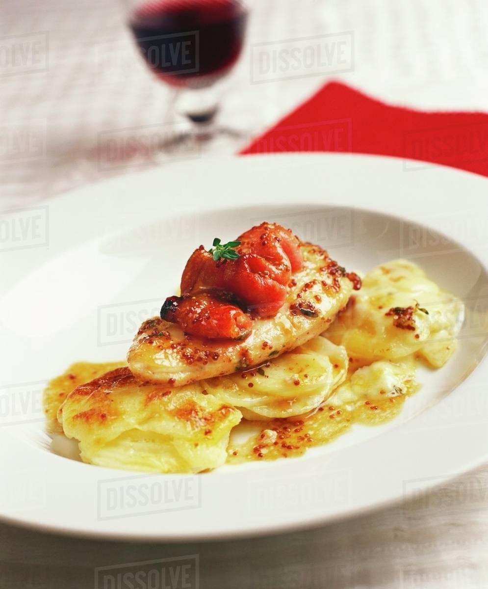 Chicken breast with tomatoes and potato gratin Stock Photo Dissolve