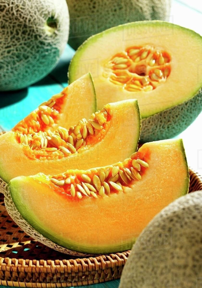 Cantaloupe melons, whole and sliced Stock Photo Dissolve