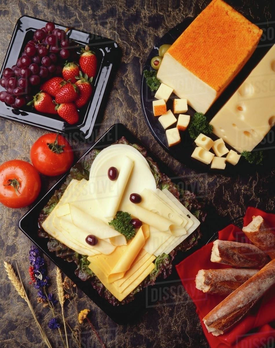Assorted Cheese Slices on a Plate; Bread, Fruit and Cheese Blocks