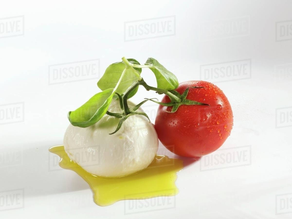 Tomato, mozzarella and basil with olive oil Stock Photo Dissolve