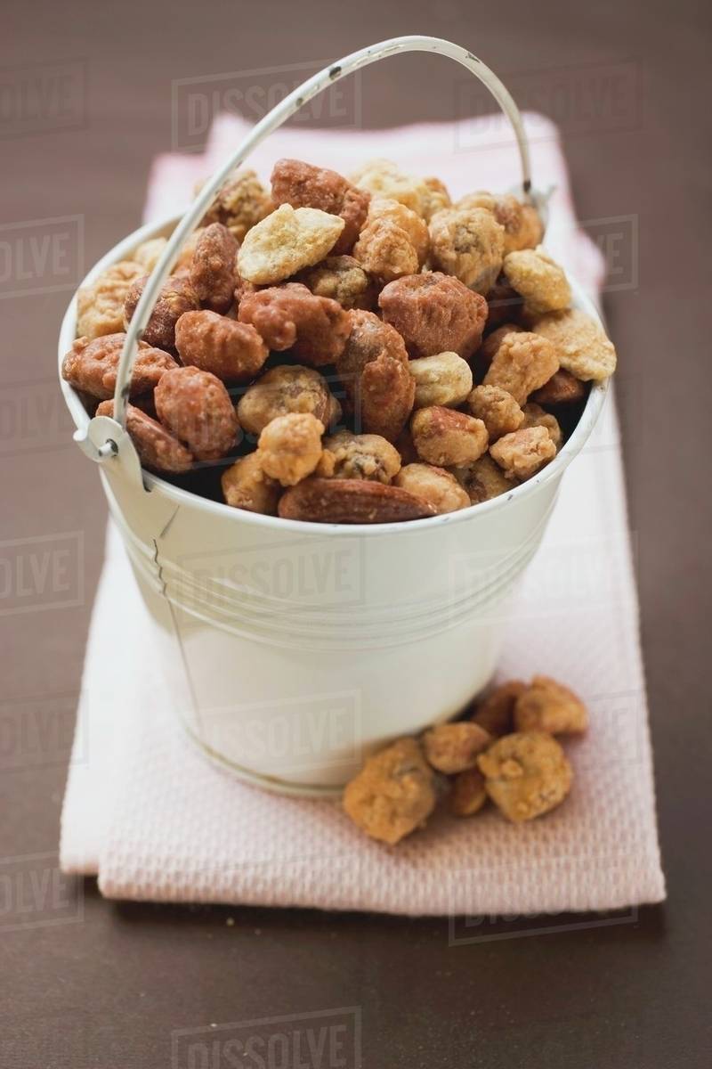 Mixed nuts to nibble in white bucket Stock Photo Dissolve