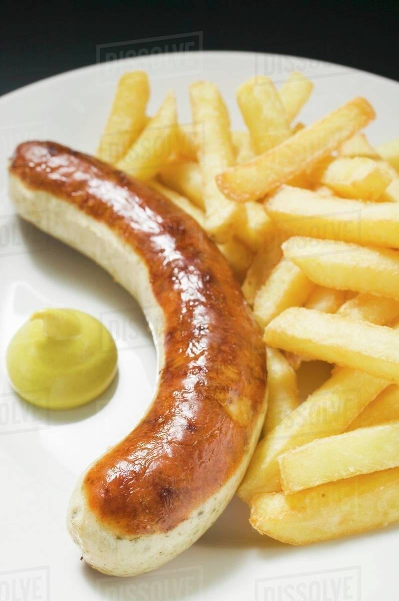 Sausage with chips and mustard on plate Stock Photo Dissolve