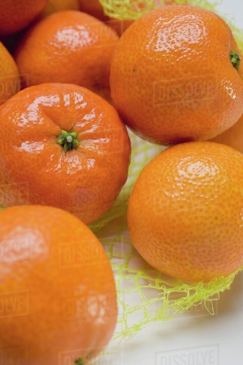 Clementines in a net (detail) Stock Photo Dissolve