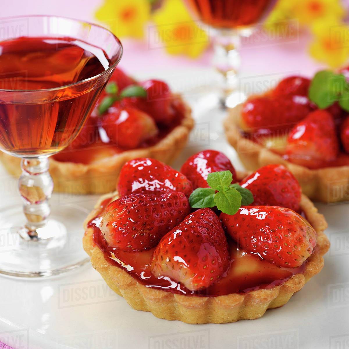 Strawberry tartlets with mint; dessert wine Stock Photo Dissolve