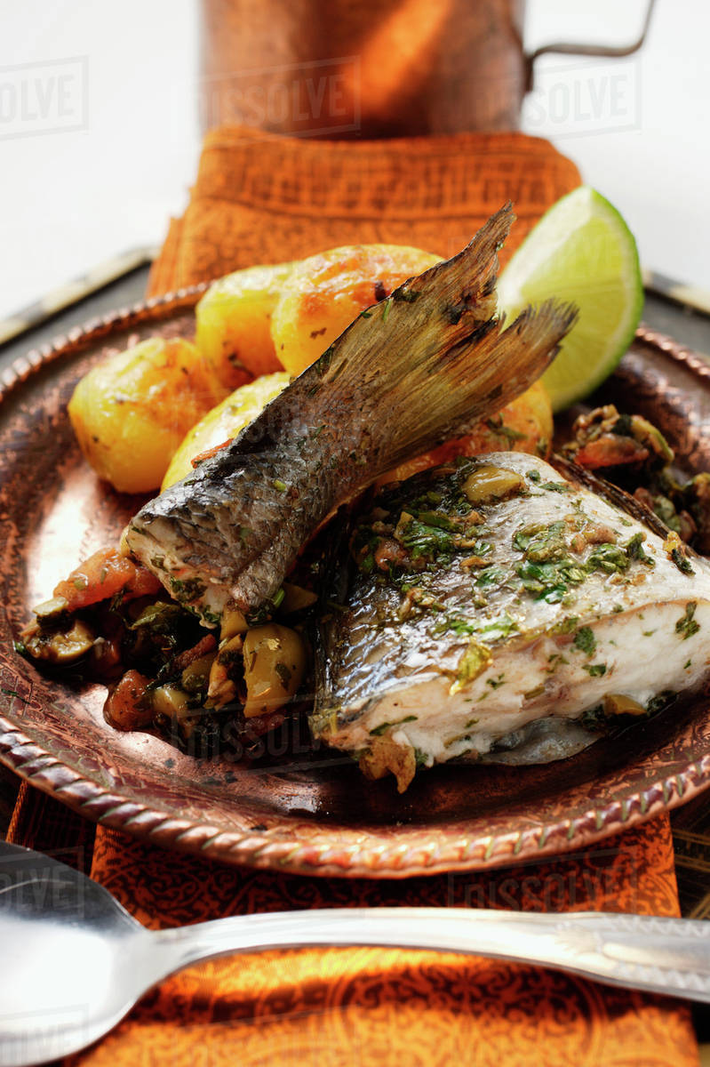 Sea bass with roast potatoes (Morocco) Stock Photo Dissolve