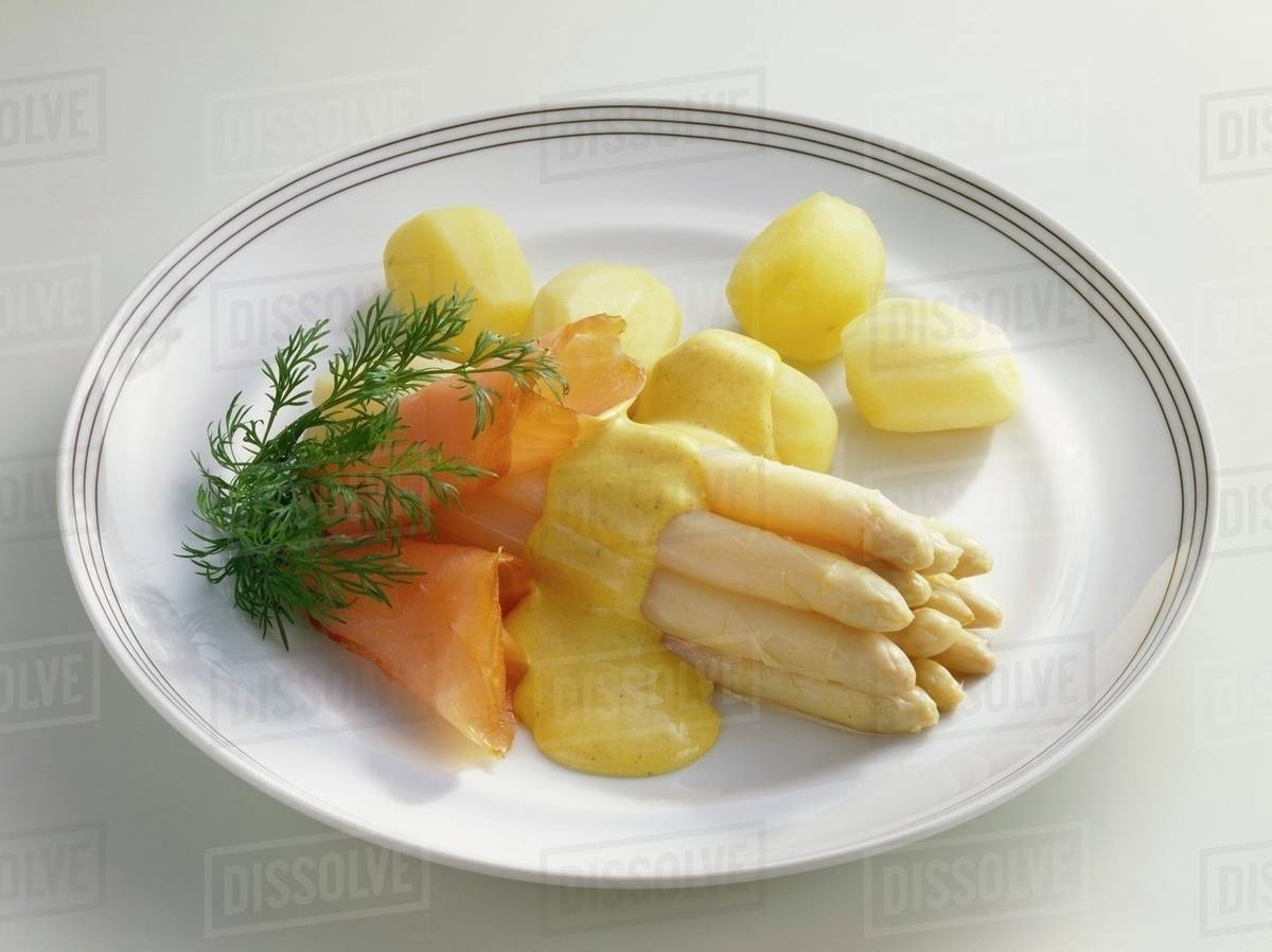 Asparagus with curry sauce, smoked salmon and potatoes Stock Photo