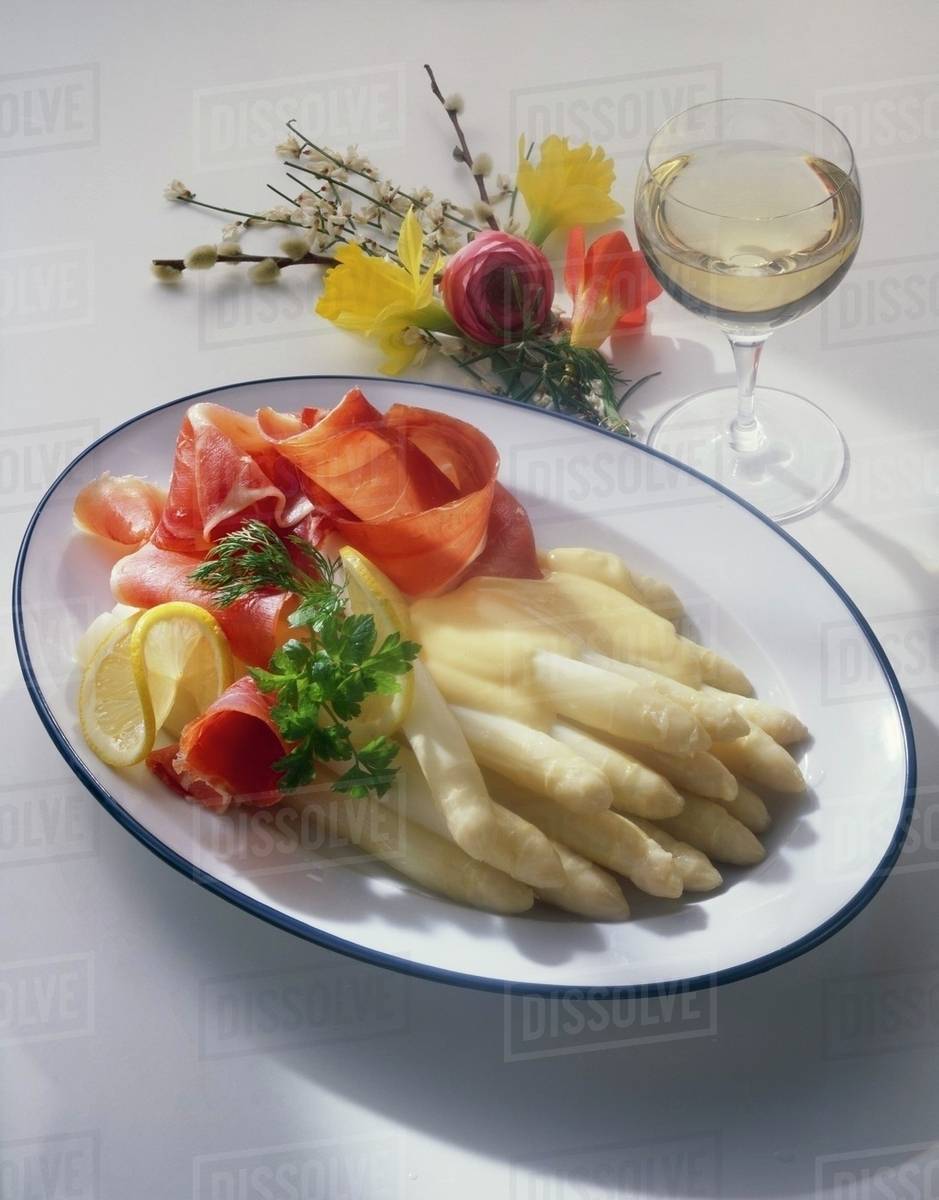 Asparagus with ham & hollandaise sauce, glass of white wine Stock
