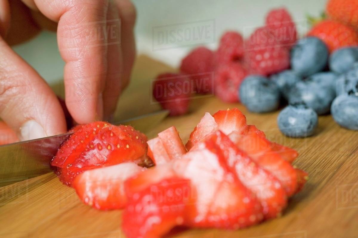 Cutting strawberries into pieces Stock Photo Dissolve