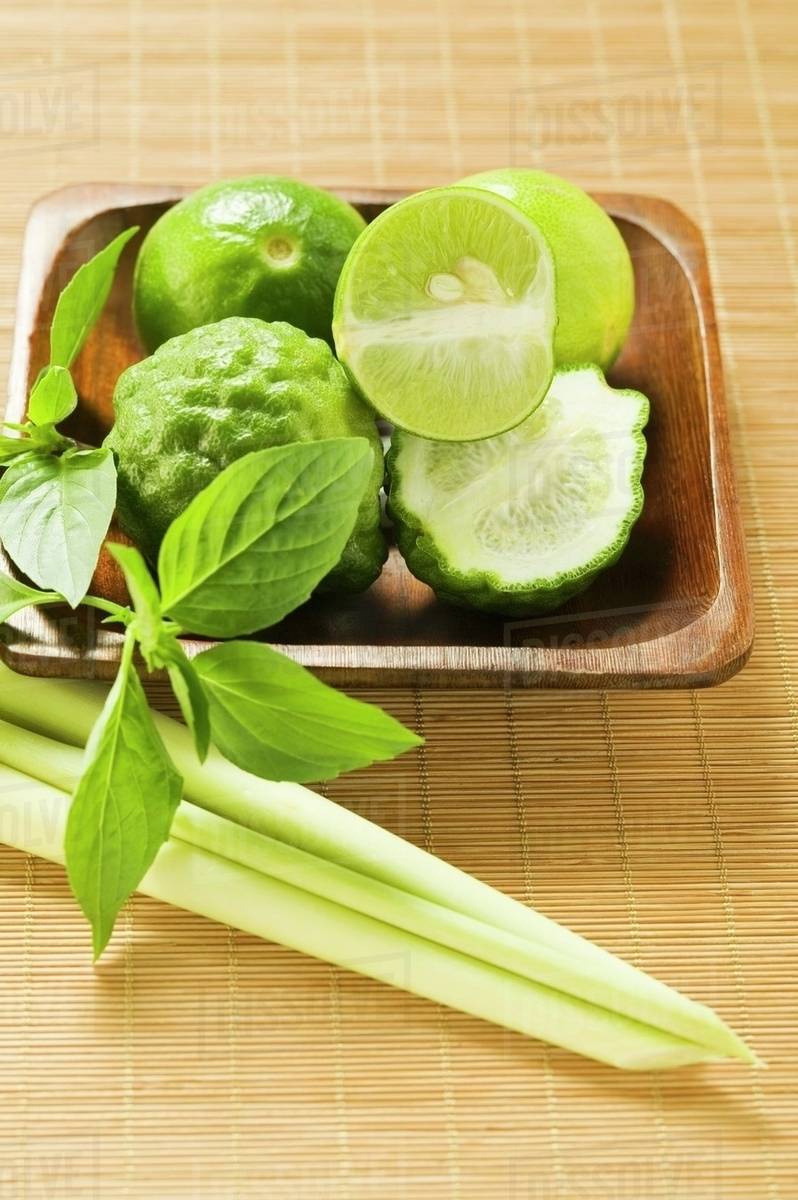 Limes, kaffir limes, Thai basil and lemon grass Stock Photo Dissolve