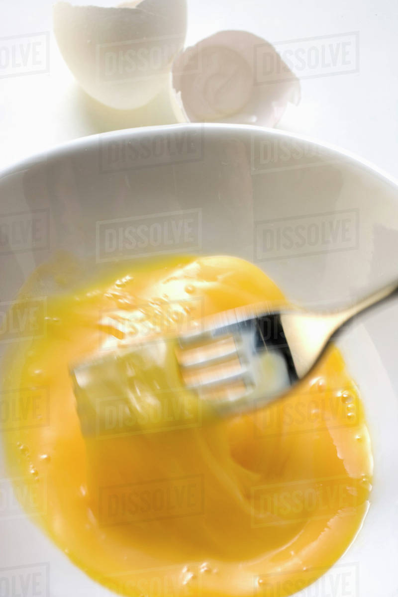 Beating egg with fork Stock Photo Dissolve