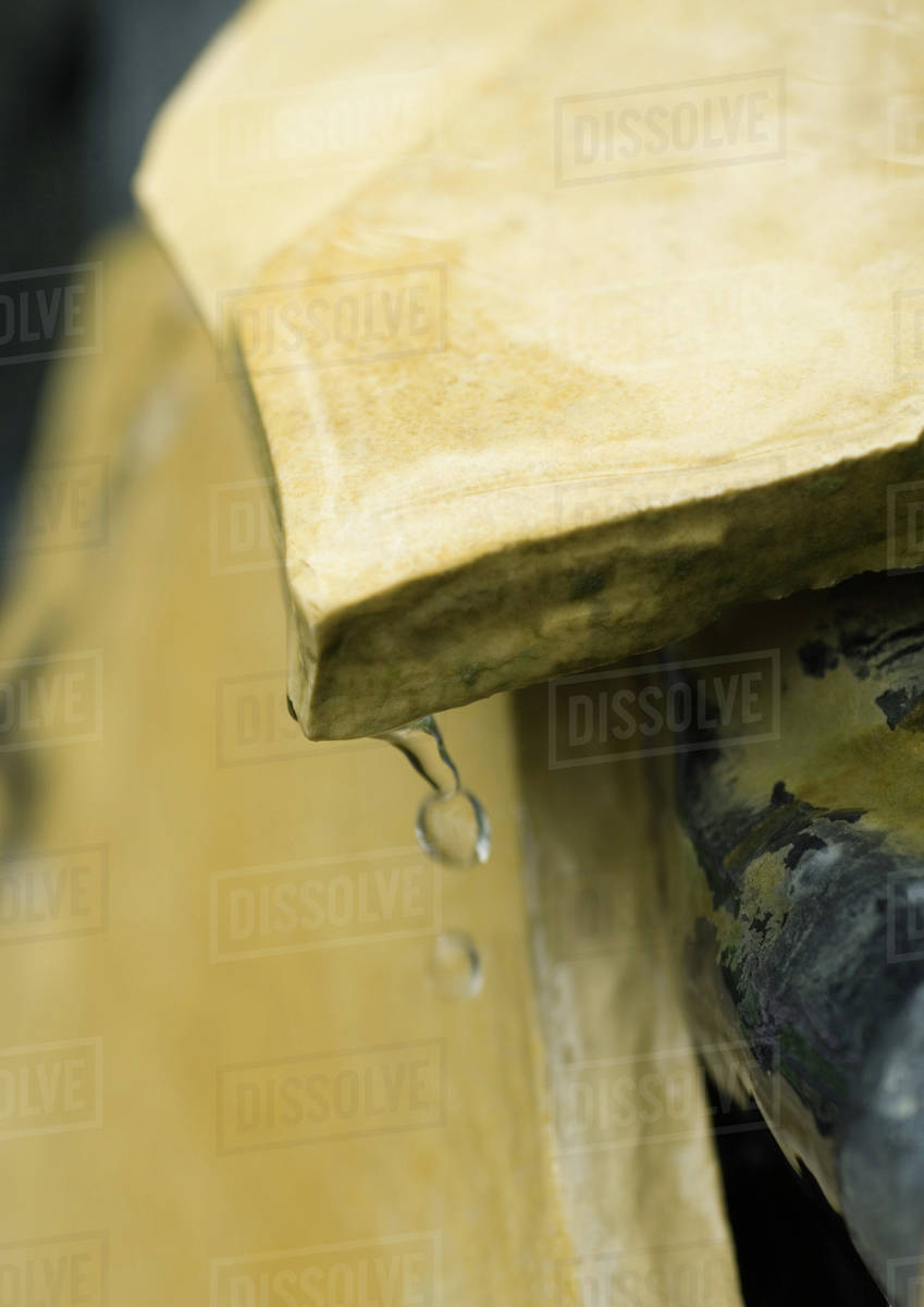 Water dripping from edge of stone, closeup Stock Photo Dissolve