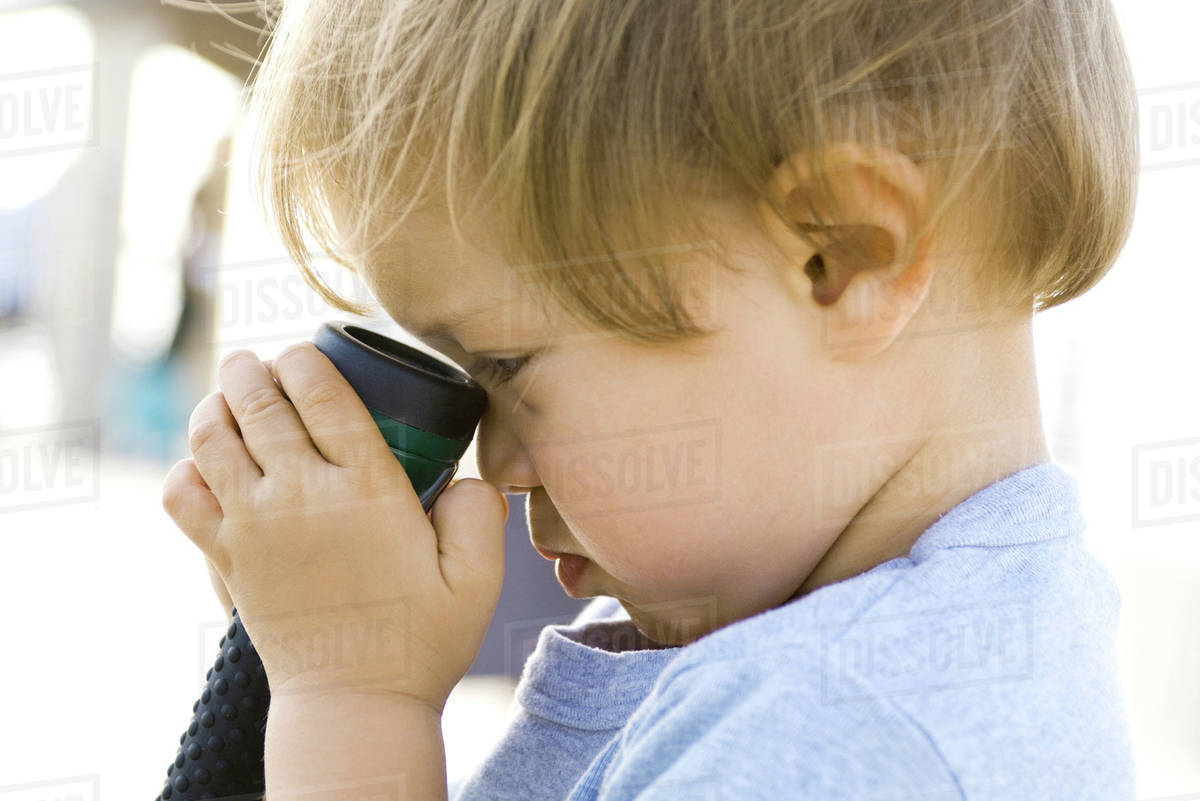 Child holding flashlight against face, side view, close-up - Royalty ...