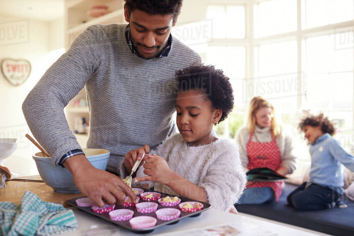 Family baking cake in kitchen at home together Stock Photo Dissolve