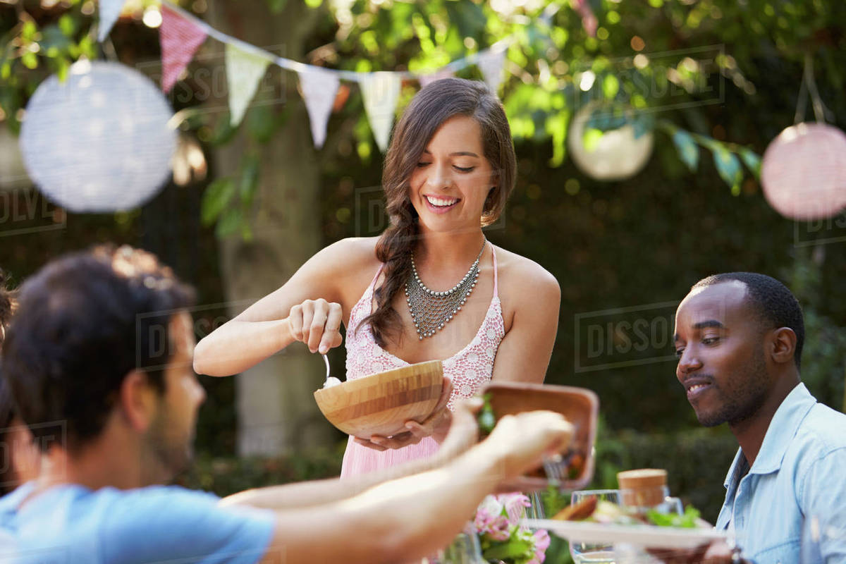 Woman Serving Food To Friends At Outdoor Backyard Party Royalty-free stock photo