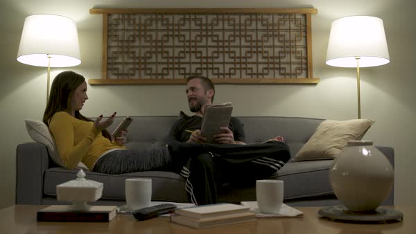 Couple Lounging On Sofa At Home Using Mobile Phone And Doing Crossword Puzzle Stock Footage Dissolve Mobile Phone And Doing Crossword Puzzle, Kind Of Sofa Or Couch Crossword