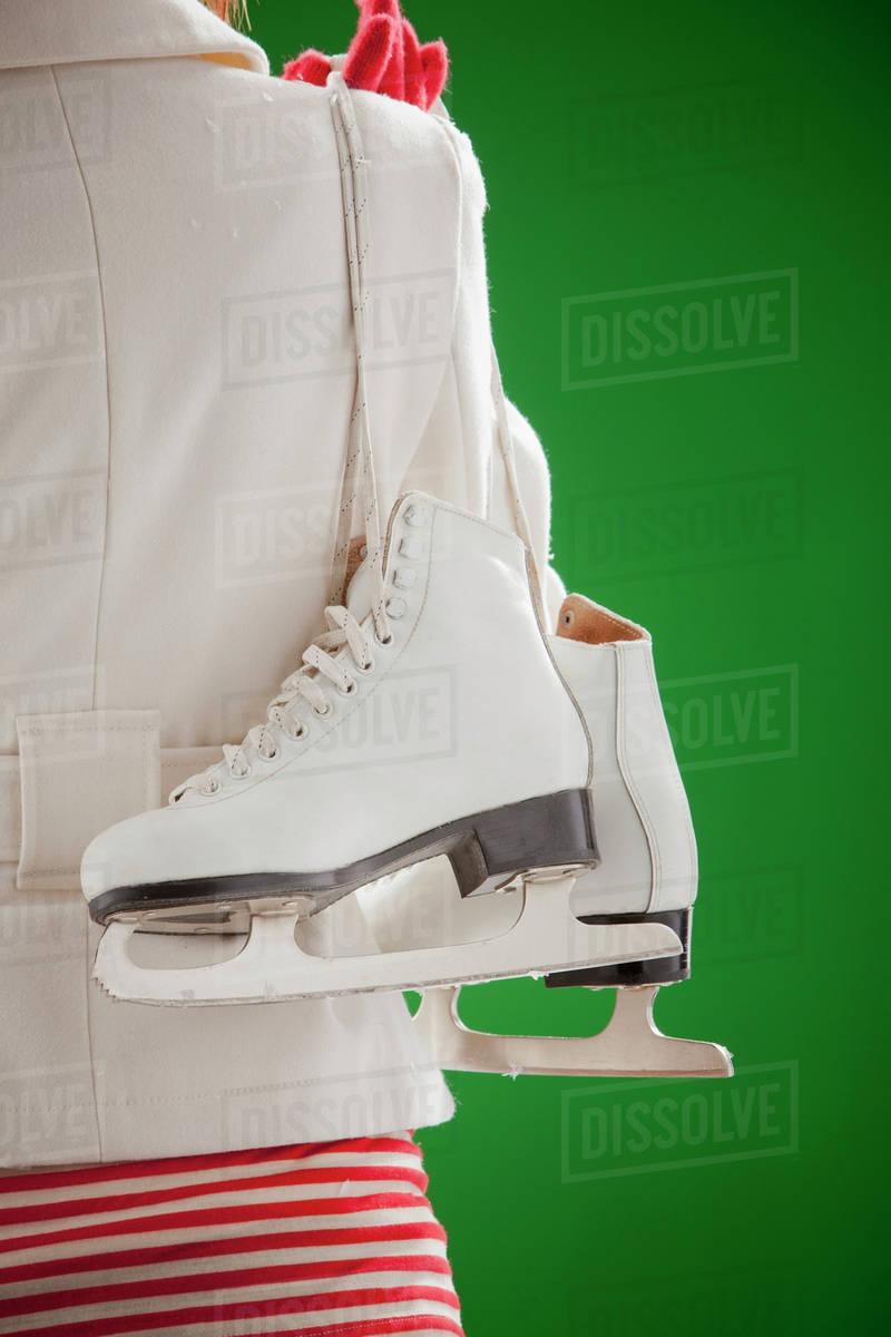 Mixed race woman carrying ice skates Stock Photo Dissolve