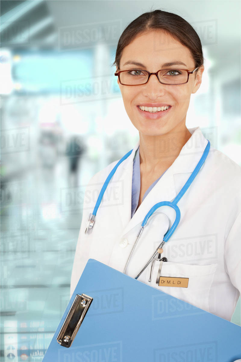 Mixed race doctor holding medical chart in hospital Stock Photo