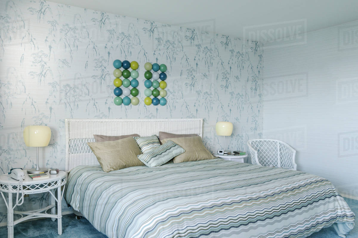 Bed and wall art in modern bedroom Stock Photo Dissolve