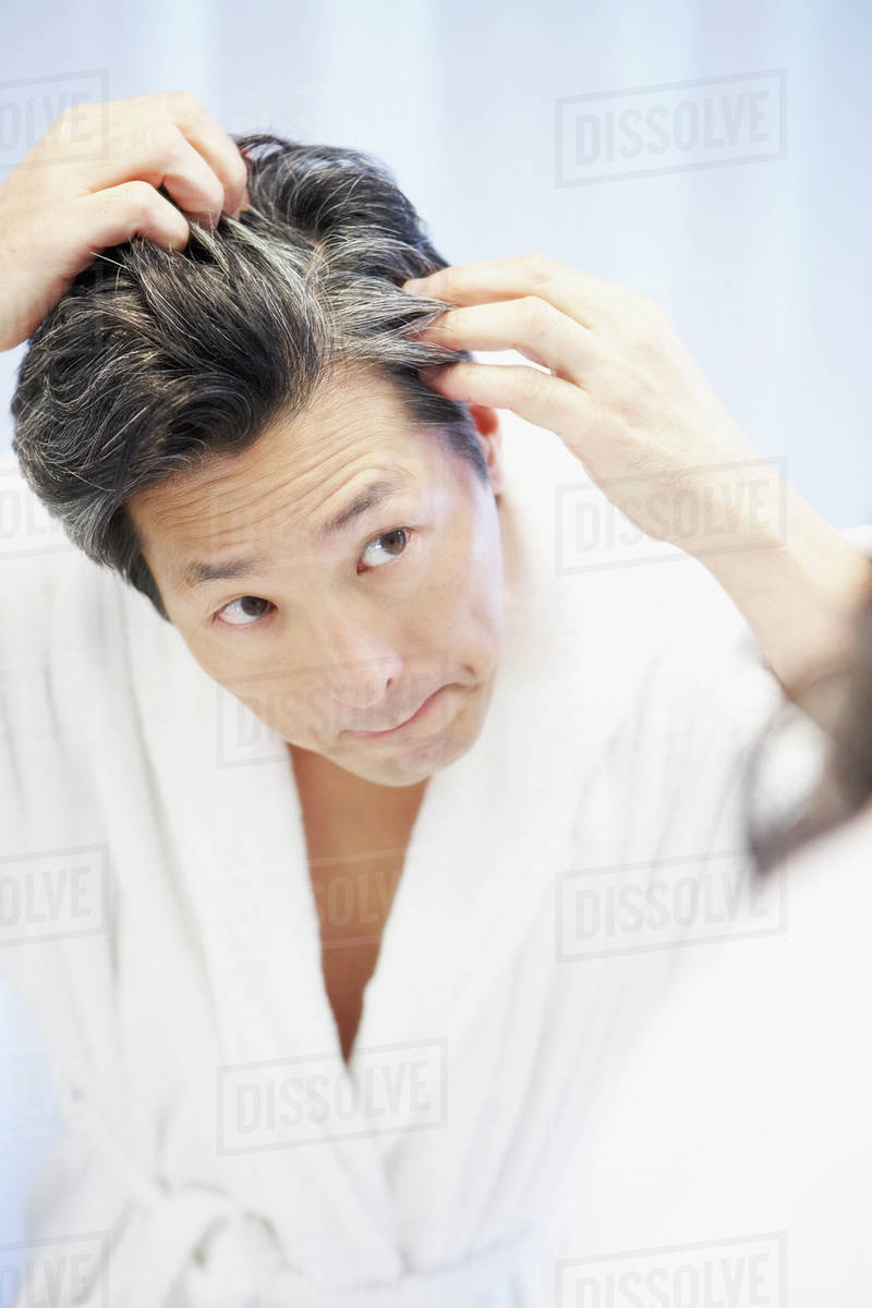 Asian Man Looking At Gray Hair In Mirror Stock Photo Dissolve