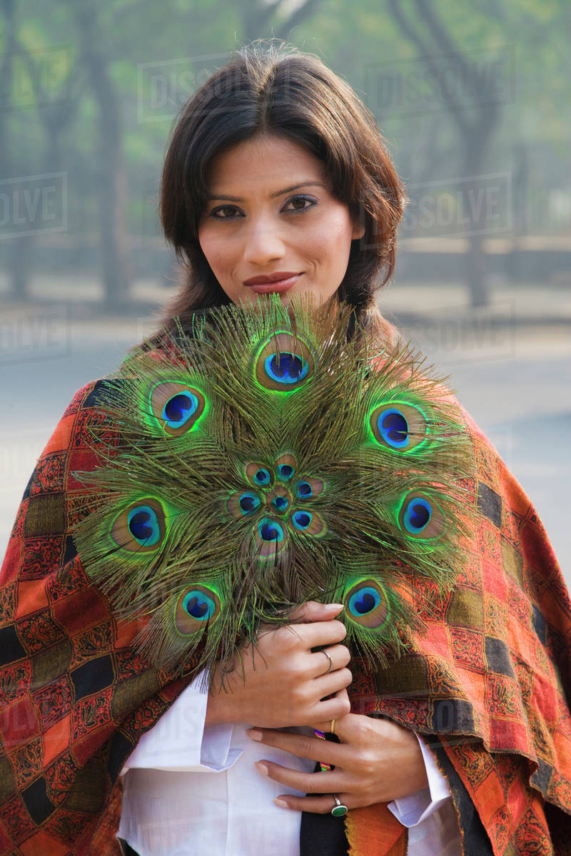 Indian woman holding peacock feather fan Stock Photo Dissolve